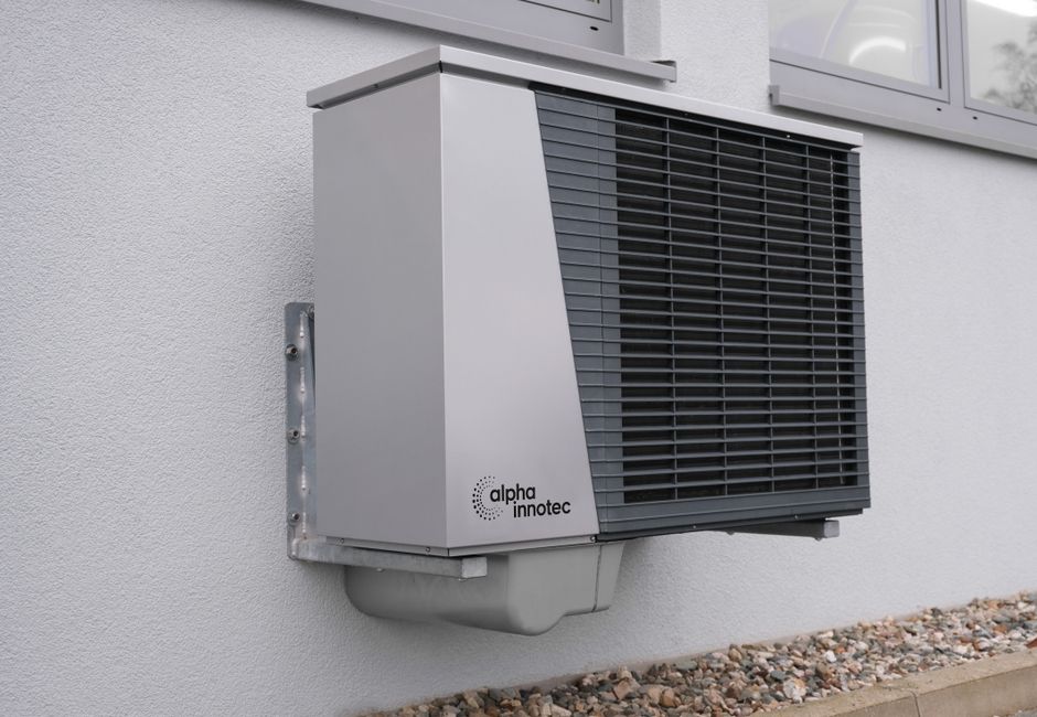 heat pump outdoor unit being installed on a UK house wall